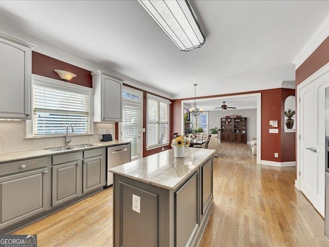 kitchen with sink, crown molding, dishwasher, gray cabinetry, and a center island