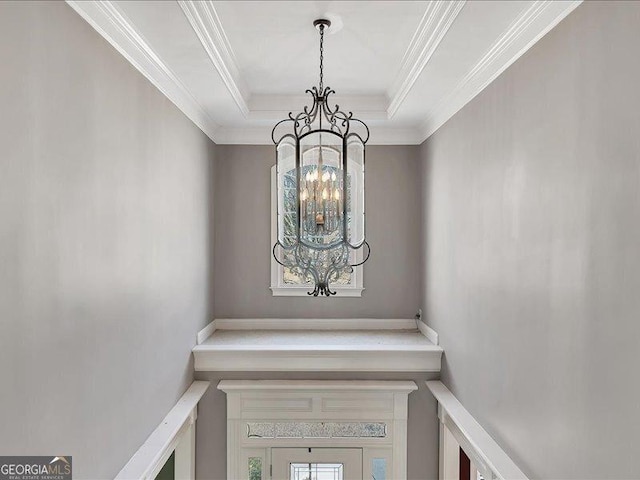 room details with ornamental molding, a tray ceiling, and a chandelier