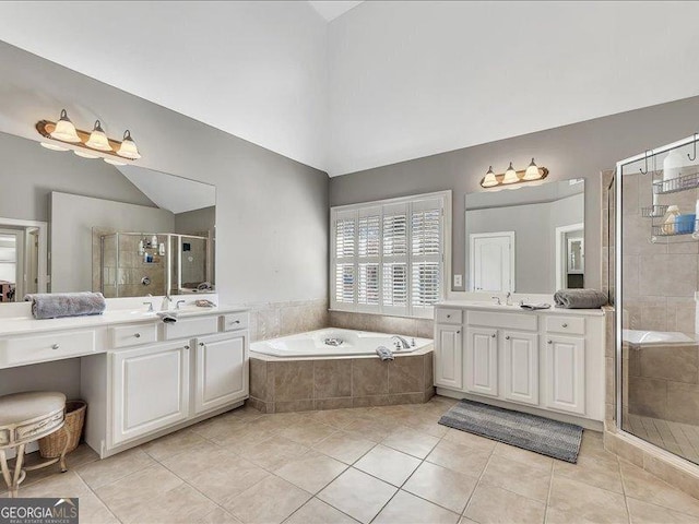 bathroom with lofted ceiling, independent shower and bath, tile patterned flooring, and vanity