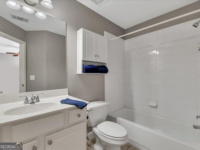 full bathroom with vanity, tiled shower / bath, and toilet