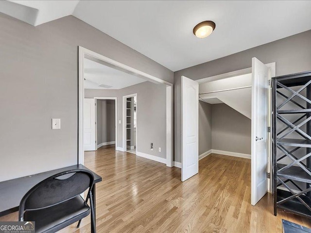 workout room with lofted ceiling and light hardwood / wood-style floors