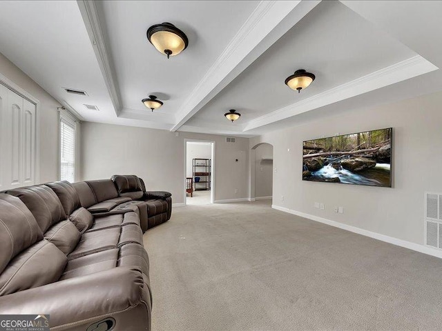 carpeted living room featuring crown molding and a tray ceiling