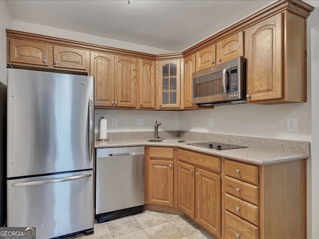 kitchen with appliances with stainless steel finishes, sink, and light tile patterned floors