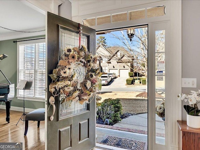 entryway featuring hardwood / wood-style flooring and ornamental molding