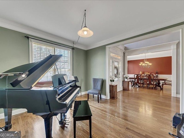 miscellaneous room with an inviting chandelier, crown molding, and hardwood / wood-style floors