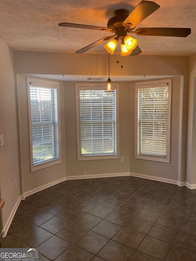 tiled spare room featuring a textured ceiling