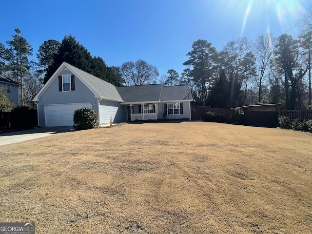 view of front of home featuring a garage, driveway, a front lawn, and fence