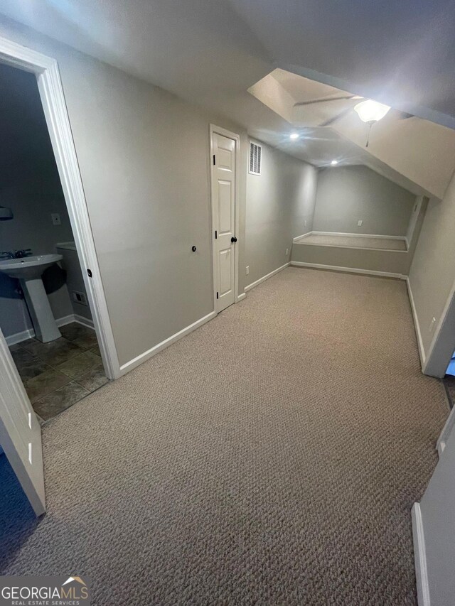 bathroom with lofted ceiling, sink, toilet, and walk in shower