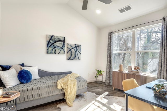 bedroom with ceiling fan, wood finished floors, visible vents, baseboards, and vaulted ceiling