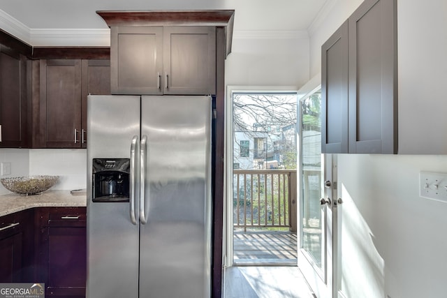 kitchen featuring ornamental molding, stainless steel refrigerator with ice dispenser, dark brown cabinetry, and light stone countertops