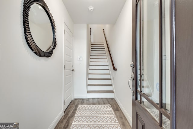 doorway to outside featuring stairway, baseboards, and wood finished floors