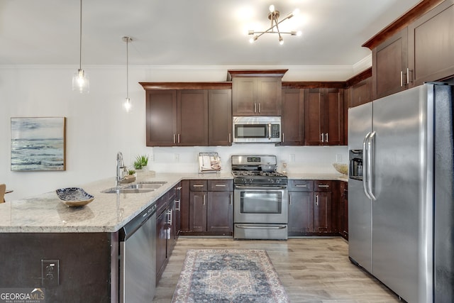 kitchen featuring light stone counters, stainless steel appliances, a peninsula, a sink, and crown molding