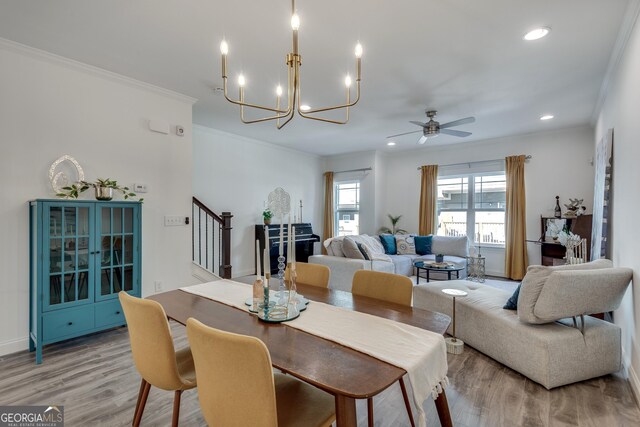 kitchen featuring appliances with stainless steel finishes, decorative light fixtures, ornamental molding, light stone counters, and dark wood-type flooring