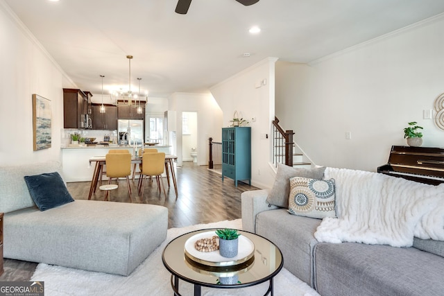 living room featuring ornamental molding, ceiling fan, stairway, and wood finished floors