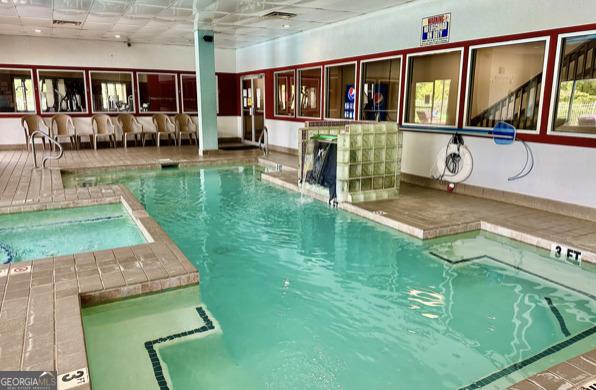 view of pool featuring exterior bar and an indoor in ground hot tub