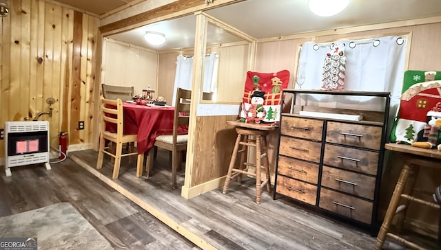 bar featuring dark wood-type flooring, wooden walls, and heating unit