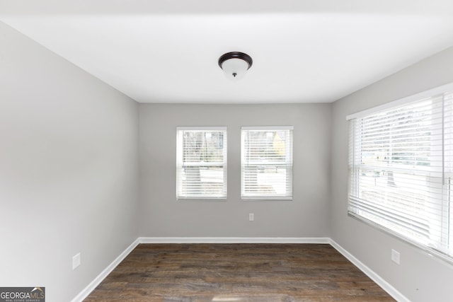 unfurnished room with dark wood-type flooring