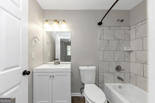 full bathroom featuring vanity, tiled shower / bath combo, and toilet