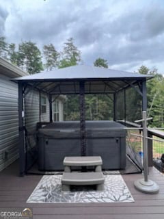 wooden deck with a gazebo and a hot tub