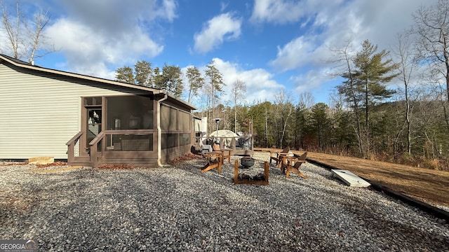 view of yard with a sunroom and an outdoor fire pit