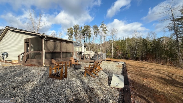 exterior space featuring a sunroom and a fire pit