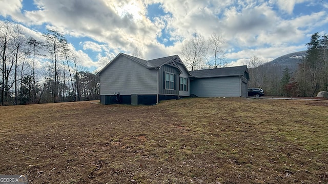 view of side of home featuring a mountain view and a lawn