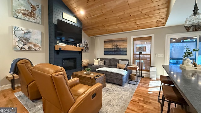 living room with lofted ceiling, a large fireplace, wooden ceiling, and light hardwood / wood-style floors