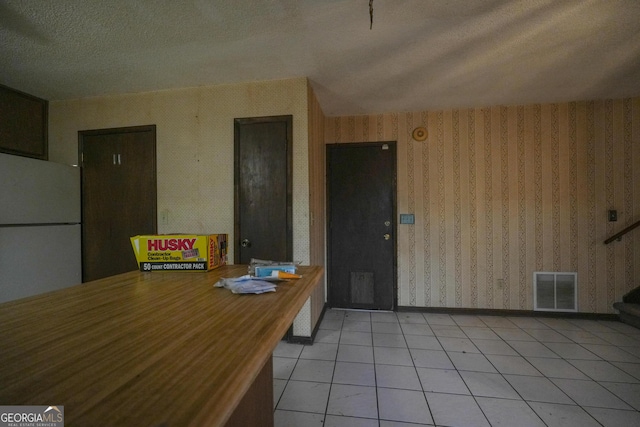 dining space with light tile patterned floors and a textured ceiling