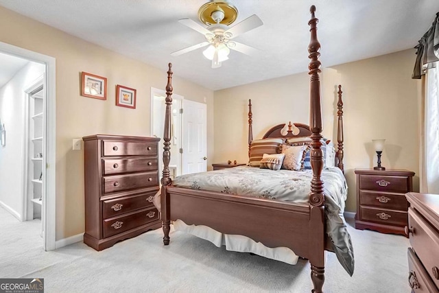 carpeted bedroom with ensuite bath and ceiling fan