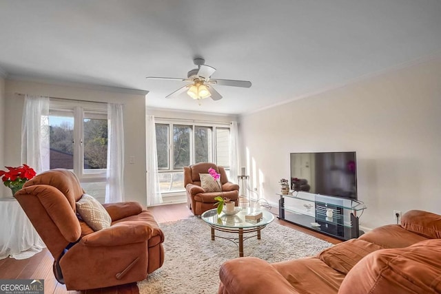 living room featuring hardwood / wood-style flooring, a wealth of natural light, ornamental molding, and ceiling fan