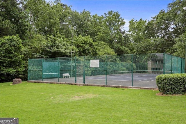 view of tennis court with a lawn