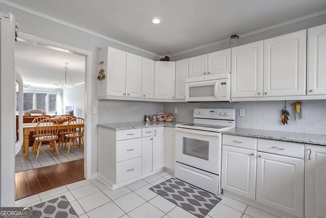 kitchen with white cabinetry, white appliances, light tile patterned floors, and backsplash