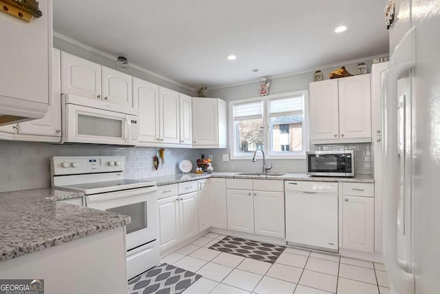 kitchen with sink, white cabinets, decorative backsplash, light stone counters, and white appliances