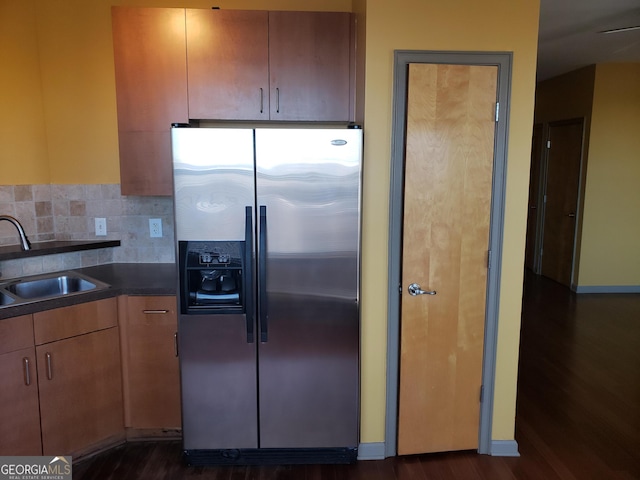 kitchen featuring stainless steel fridge with ice dispenser, dark hardwood / wood-style floors, sink, and decorative backsplash