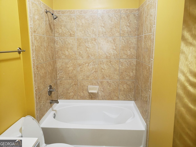 bathroom with tiled shower / bath combo and toilet