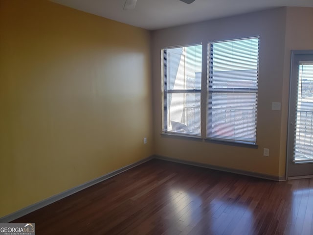 unfurnished room with ceiling fan and dark hardwood / wood-style flooring