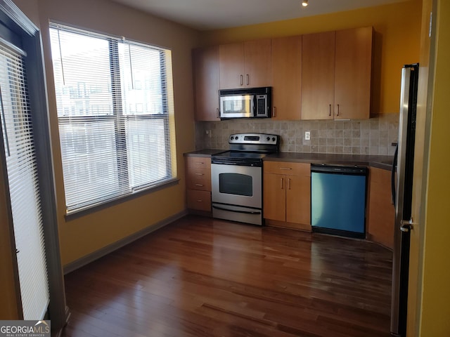 kitchen featuring dark wood-type flooring, stainless steel appliances, and decorative backsplash