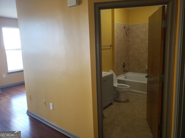 full bathroom featuring vanity, toilet, tiled shower / bath combo, and wood-type flooring