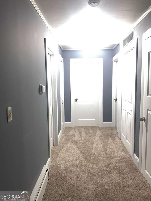 corridor featuring ornamental molding and carpet