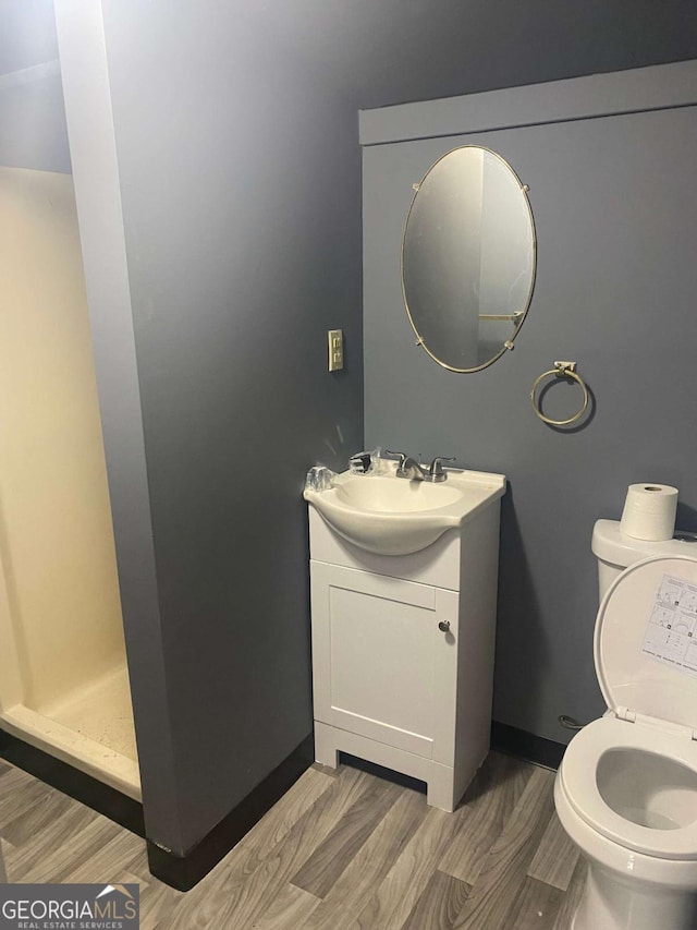 bathroom with vanity, a shower, wood-type flooring, and toilet