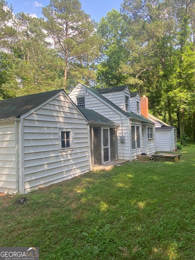 rear view of house featuring a yard