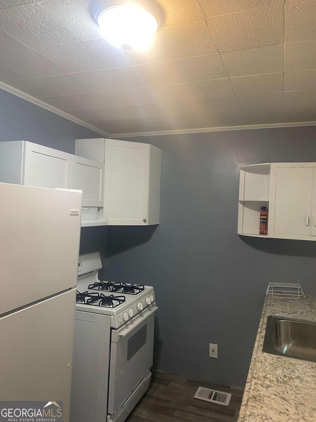 kitchen featuring white appliances, white cabinetry, light stone counters, ornamental molding, and dark hardwood / wood-style flooring