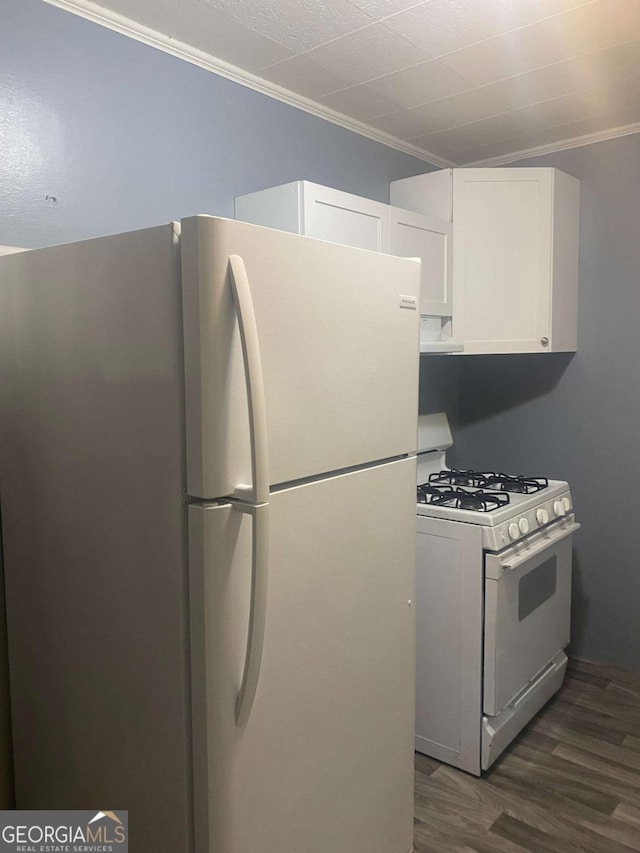 kitchen with white appliances, ornamental molding, dark hardwood / wood-style flooring, and white cabinets