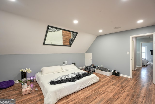 bedroom with dark wood-type flooring and vaulted ceiling