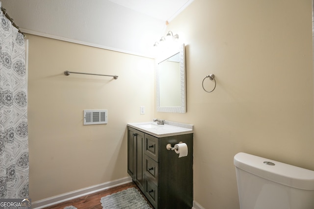 bathroom with vanity, wood-type flooring, and toilet