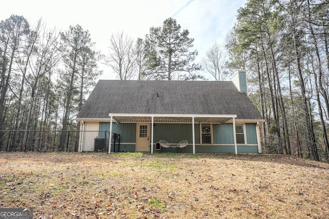 rear view of house with a yard and central air condition unit