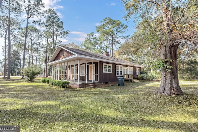 view of side of property with a yard and a sunroom