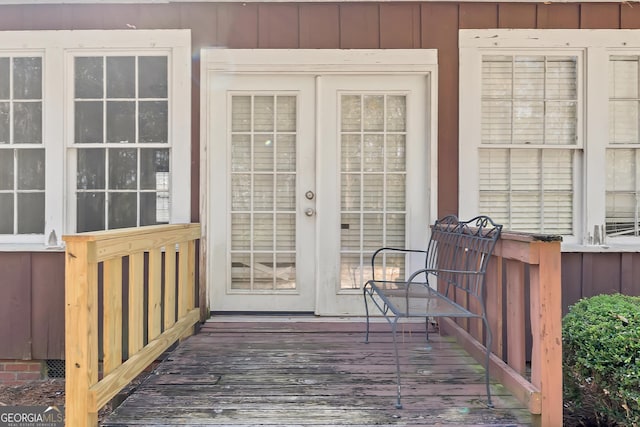 view of exterior entry with a wooden deck and french doors