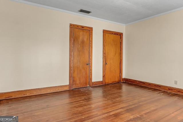 empty room featuring hardwood / wood-style flooring and ornamental molding