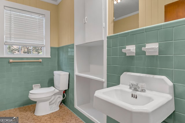 bathroom with tile walls, sink, crown molding, and toilet